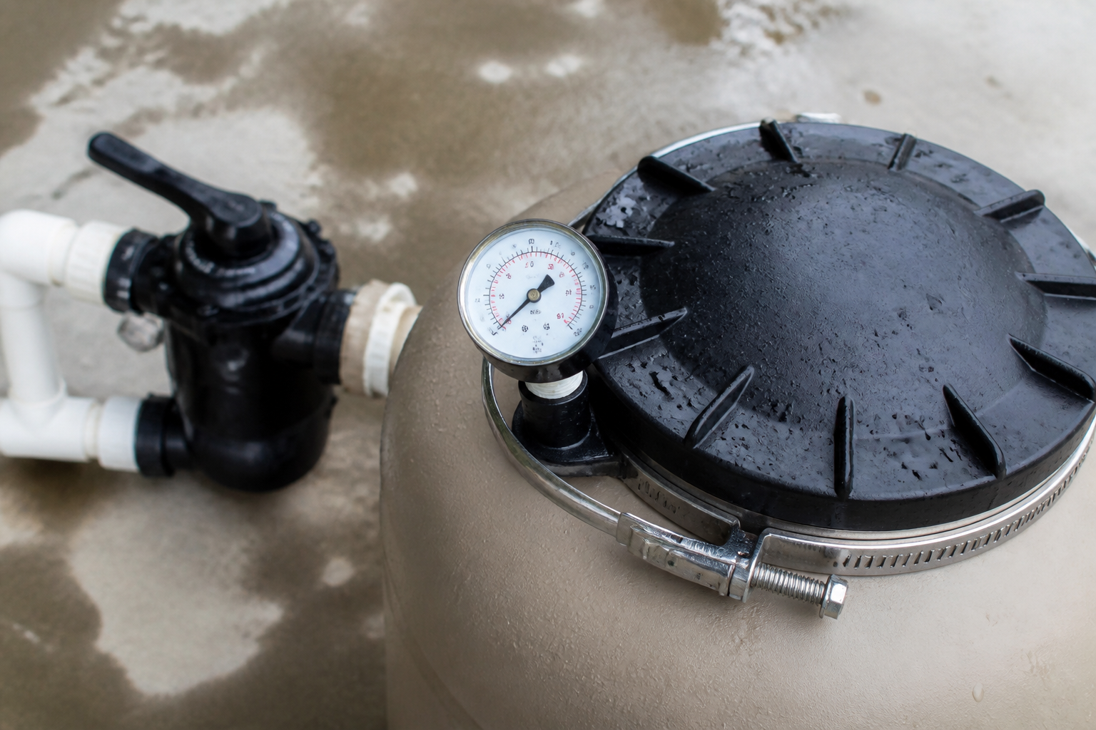 Pressure gauge and lid on a sand filter tank